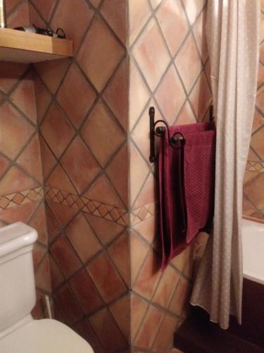 uma casa de banho com WC e toalhas penduradas numa parede em Ca Bernia em Bernia