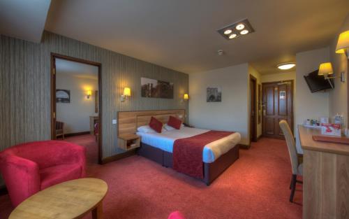 um quarto de hotel com uma cama e uma cadeira em Windmill Farm Lincoln by Greene King Inns em Lincoln