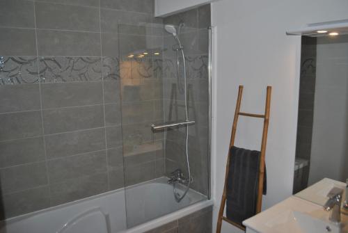 uma casa de banho com um chuveiro, uma banheira e um lavatório. em appartements T2 ou T3 idéalements situés em Brech