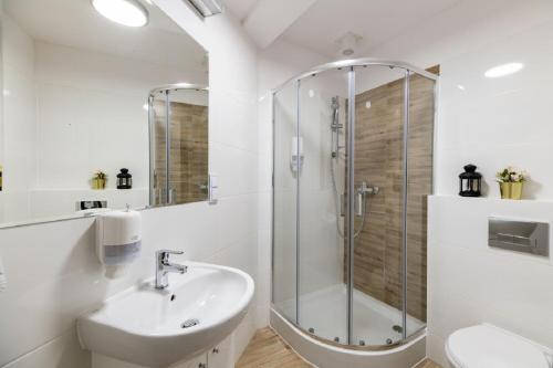 a white bathroom with a shower and a sink at DIETLA 99 APARTMENTS - IDEAL LOCATION - in the heart of Krakow in Kraków