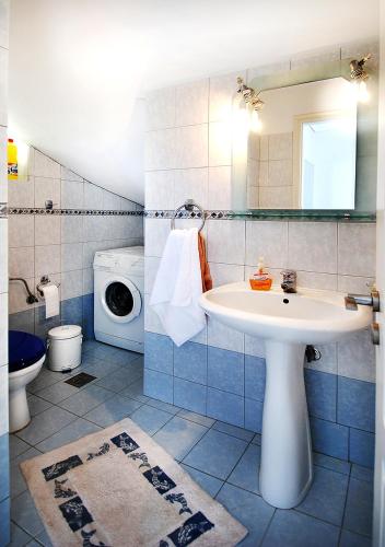 a bathroom with a sink and a washing machine at VILLA SUNSET 1 in Paralia Vrachou
