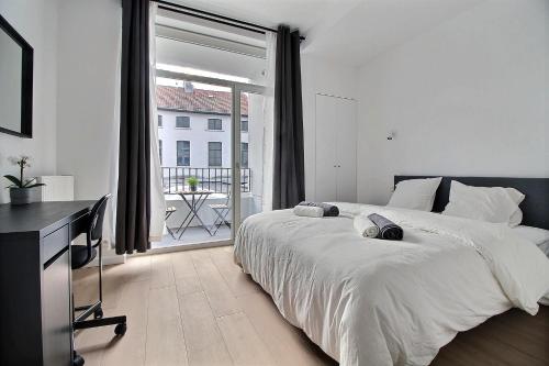 a bedroom with a large bed and a large window at Rent a Flat - Bruxelles in Brussels