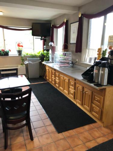 a kitchen with a counter and a table and chairs at Latham Inn in Latham