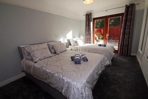 a bedroom with two beds with sandals on the bed at Modern Belfast Apartment in Belfast