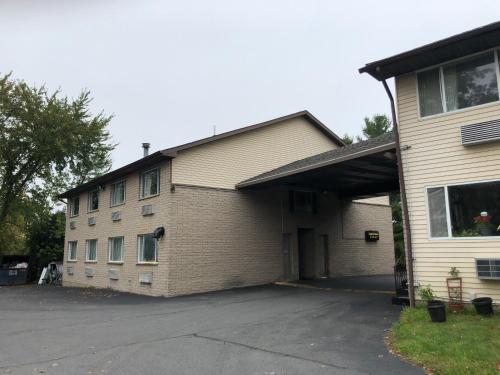 a large brick building with a garage next to a house at Latham Inn in Latham