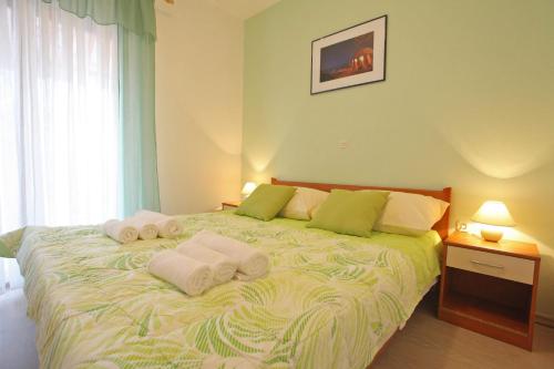 a bedroom with a bed with towels on it at Apartments Villa Mareta in Sukošan