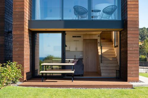a house with a table and a bench in front of it at Cabañas de Canide in A Coruña
