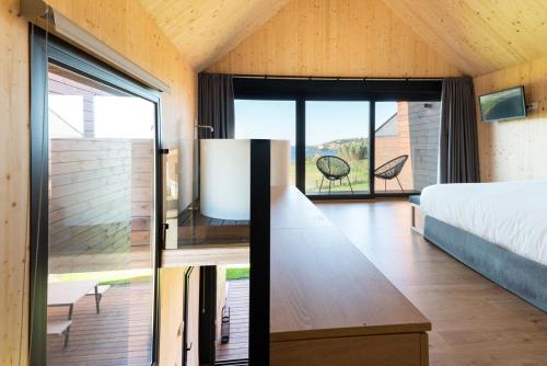 a bedroom with a bed and a large window at Cabañas de Canide in A Coruña