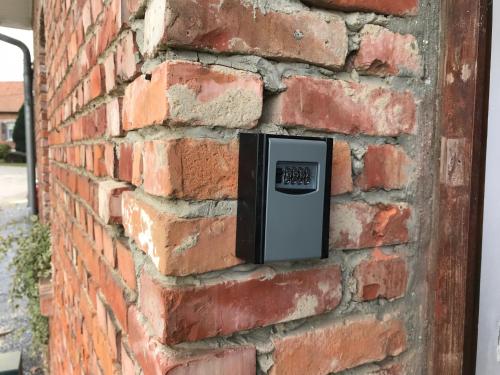 a brick wall with a clock on it at Maison 2Ch - 4 pers en Picardie parking gratuit - by La Source d'OrFée in Courcelette