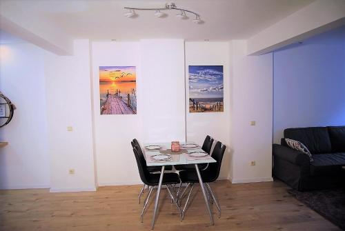 a dining room with a table and chairs and a couch at Hildastraße 1 appart.2 in Friesenheim