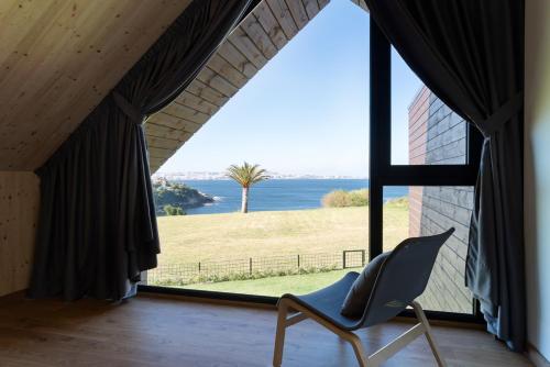 a chair in a room with a large window at Cabañas de Canide in A Coruña