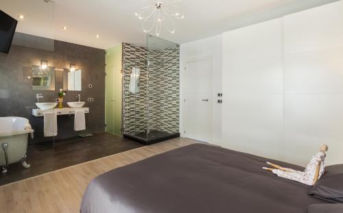 ソン・サルベーラにあるMafloras Luxury&Beach Apartmentのベッドルーム1室(ベッド1台付)、バスルーム(シンク付)