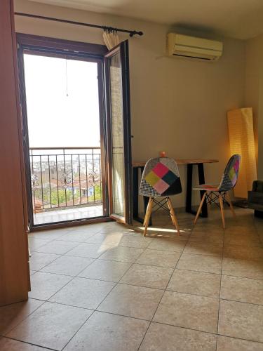 a living room with a table and chairs and a balcony at Studios Arabas in Thessaloniki