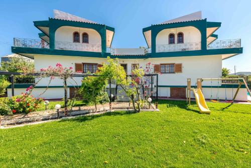 a house with a playground in the yard at Villas Marianna in Kalavárda