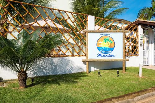 una señal para un hotel con una palmera en la hierba en Recanto Maranduba, en Ubatuba