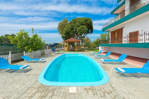 a swimming pool with chairs and a gazebo at Villas Marianna in Kalavárda