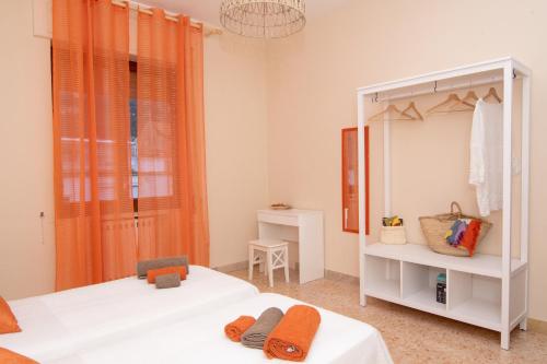 two beds in a room with orange curtains at B&B Syrentum in Sorrento