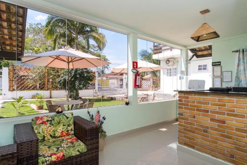a living room with a chair and an umbrella at Recanto Maranduba in Ubatuba