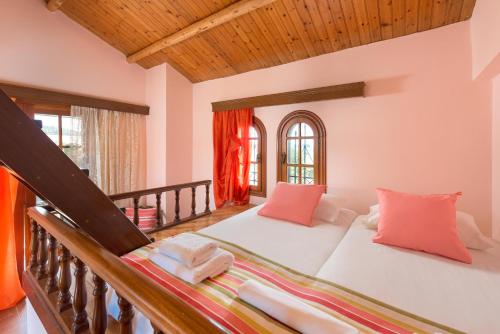 uma sala de estar com uma grande cama branca com almofadas laranja em Villas Marianna em Kalavárda
