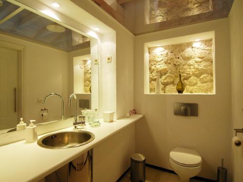 a bathroom with a sink and a toilet and a mirror at Ferienhaus in Kavalos in Kávallos