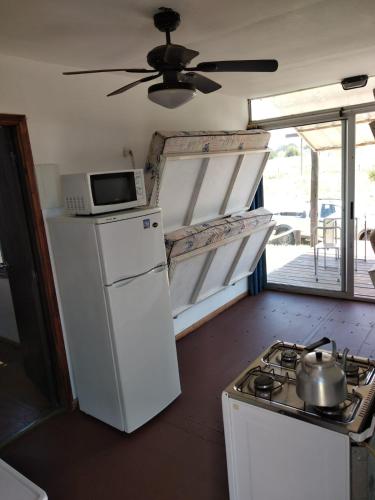 una cucina con fornelli, frigorifero e microonde di La Isla a Punta Del Diablo