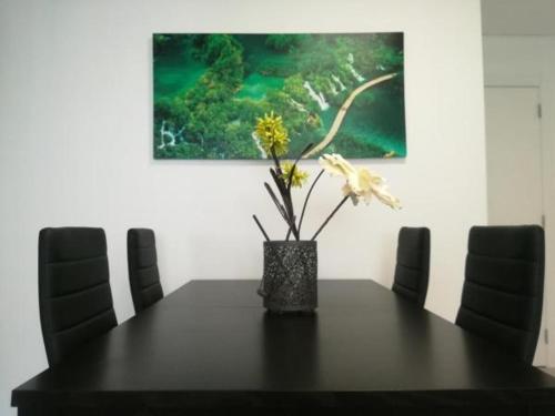 a black table with a vase with flowers on it at Irís Apartment in Pombal