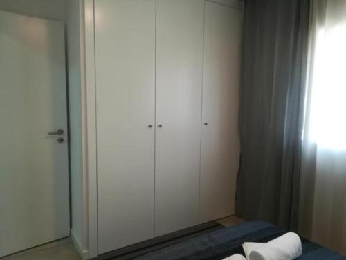 a bedroom with white cabinets and a mirror at Irís Apartment in Pombal
