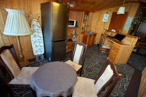 a kitchen with a table and a refrigerator at Karczma Pod Topolami in Ratowo Piotrowo