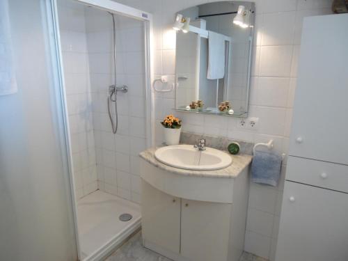 La salle de bains blanche est pourvue d'un lavabo et d'une douche. dans l'établissement Apartamento Playa Mar Azul, à Alcúdia