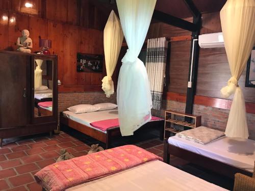 a room with three beds and a mirror at Charming Countryside Homestay in Ben Tre