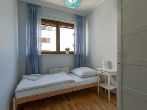 Habitación pequeña con cama y ventana en VacationClub - Platan 2E Apartament 12, en Świnoujście