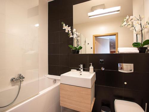 y baño con lavabo, aseo y espejo. en VacationClub - Platan 2E Apartament 12, en Świnoujście