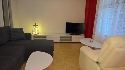 uma sala de estar com um sofá e uma televisão em Lomaosake Meritullinraitti 1 B20 em Oulu