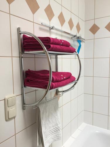 einen Handtuchhalter im Bad mit roten Handtüchern in der Unterkunft Haus 32 in Wismar