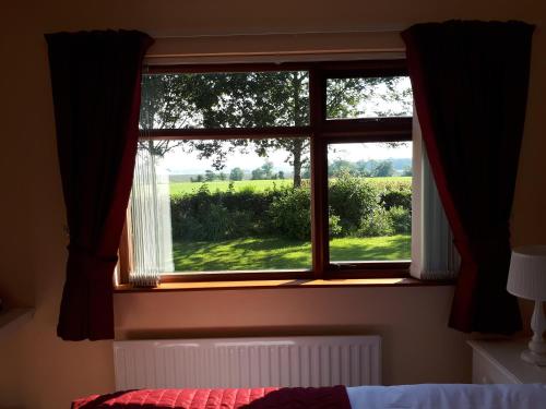 a window with a view of a green field at Dewhamill in Bellaghy