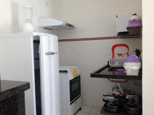 a small kitchen with a sink and a stove at Chalés Ubatuba 102 - P. Itaguá in Ubatuba