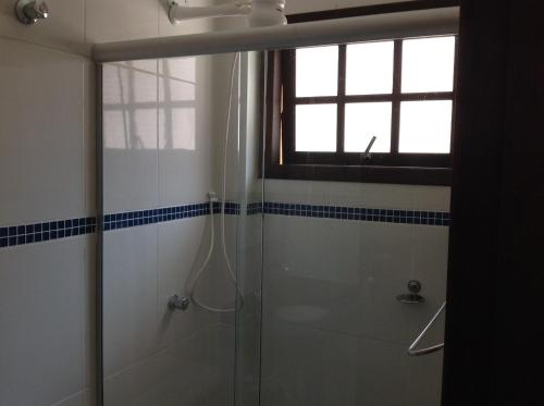 uma casa de banho com um chuveiro e uma janela em Chalés Ubatuba 102 - P. Itaguá em Ubatuba