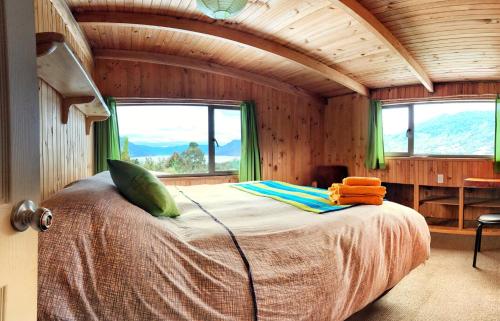 1 dormitorio con 1 cama en una habitación con ventanas en Patagonia Nativa, en Cochamó