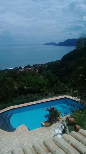 a swimming pool with a view of the ocean at Vila Lia in São Sebastião