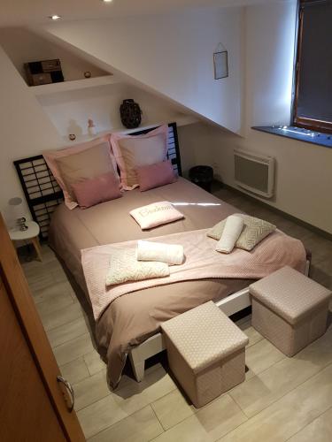 a bedroom with a large bed with pink pillows at Au detour de Gournay in Gournay-en-Bray