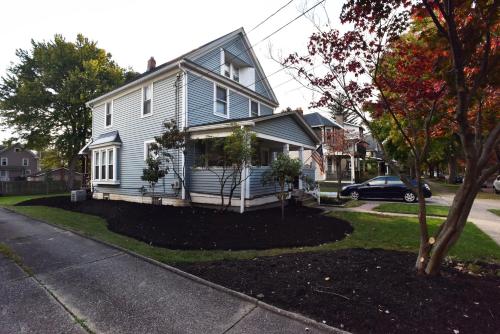 a white house with a porch on a street at Berrodin Bed & Breakfast in Akron