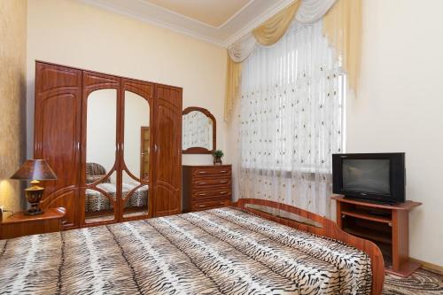 リヴィウにあるLvivPodobovo Apartmentsのベッドルーム(大型ベッド1台、テレビ付)