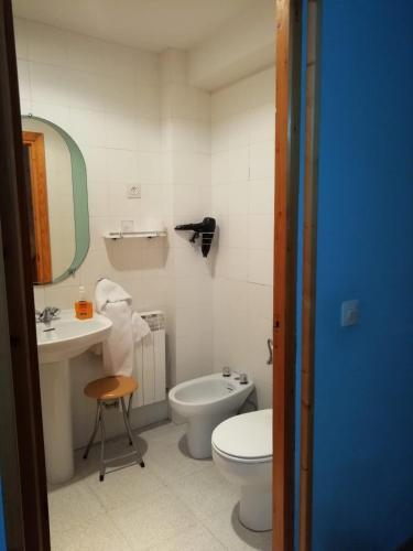 a bathroom with a toilet and a sink and a mirror at La Puente 10 de Gredos in Hoyos del Espino