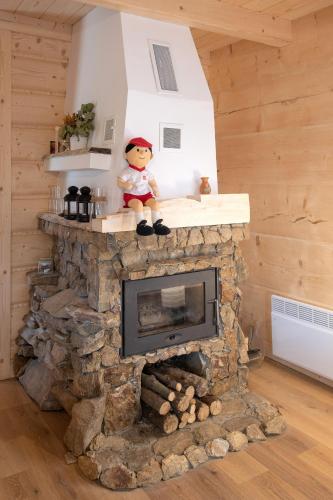 a stone fireplace with a doll sitting on top of it at Osada Sudecka in Lądek-Zdrój