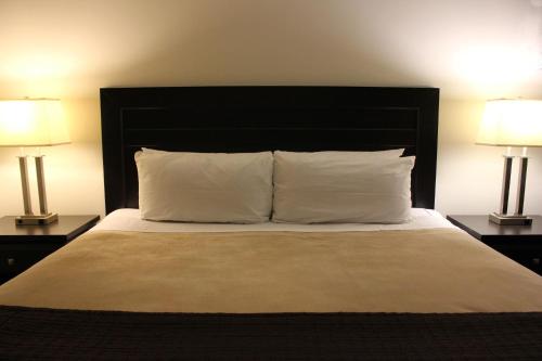 a bedroom with a large bed with two lamps at Coronet Hotel in Prince Albert