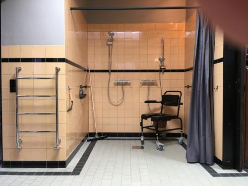 baño con ducha y silla negra en Boerderij Honswijck en Weesp