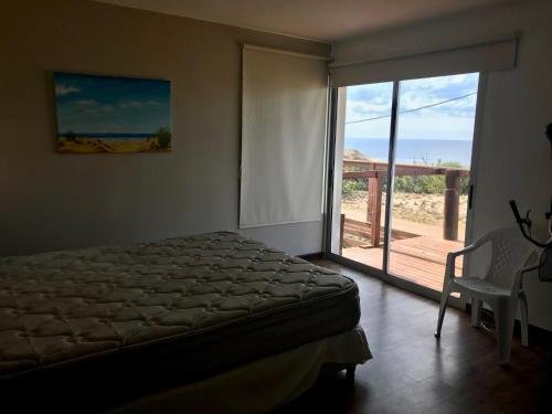 Schlafzimmer mit einem Bett und einer Glasschiebetür in der Unterkunft Primafila in Sauce de Portezuelo