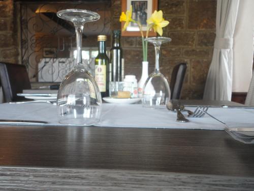 a table with two wine glasses on a white table cloth at The Dog & Partridge Country Inn in Ashbourne