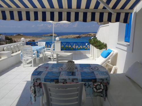a patio with a table and chairs and the ocean at Blue and White Studios & Apartments in Lefkos Karpathou