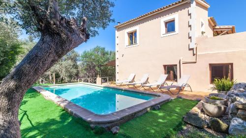 una piscina di fronte a una casa con un albero di Son Vent a Valldemossa
